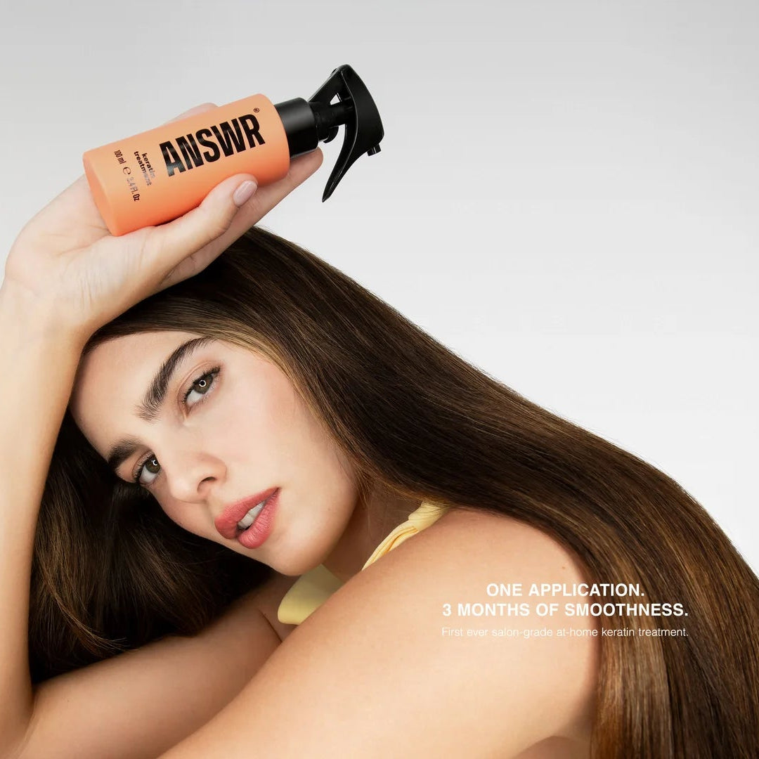 Woman holding a bottle labeled 'The Answer' with text on a white background